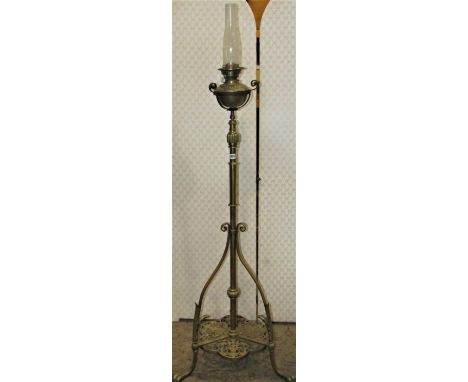 A Victorian brass telescopic oil lamp standard with pierced and scrolling detail on lions paw feet 