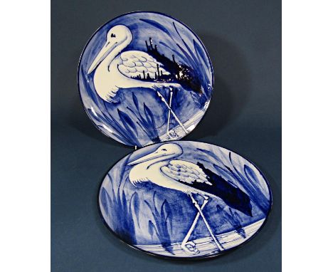 A pair of blue and white painted ceramic chargers with heron decoration with impressed and printed marks to base - Bristol Po