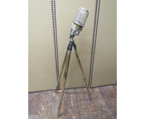 A bronze bulkhead light, later mounted on a vintage tripod 