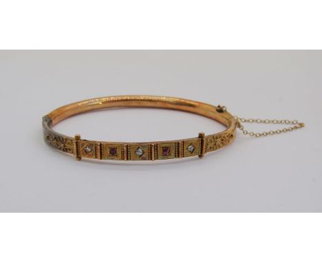 Late 19th century 15ct hinged bangle set with rubies and diamonds, 8.6g (af) 