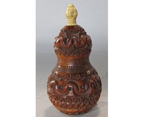 A coquilla nut thread holder profusely carved with a screw top and bone finial 9cm tall. 