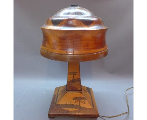 A 1930's table lamp with marquetry inlay body depicting palm and pine trees and treen shade