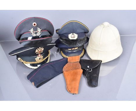 An assortment of overseas caps, together with a Pith helmet, two holsters and a Wilkinson Export &amp; Co belt buckle and bel