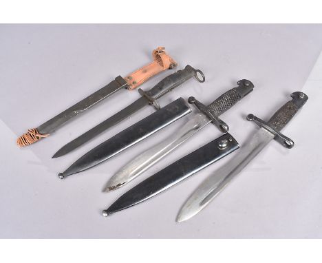 Two Spanish Bolo bayonets and scabbards, one with matching numbers, together with a French M1956 CTME bayonet and scabbard (6
