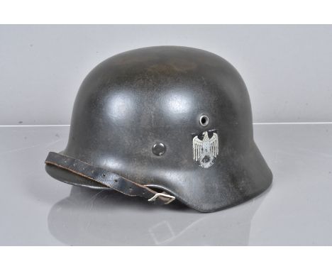 A WWII period De-Swastikaed M40 Heer double decal helmet, with German Tricolour to one side and eagle to the other, stamped E