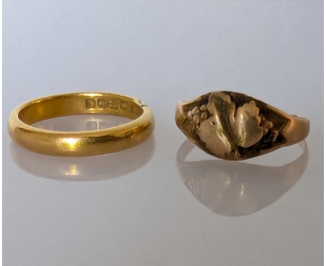A 22ct yellow gold wedding band, size K, 4.4g and a 9ct gold signet ring with oak leaf design, 1.55g, both hallmarked and bot
