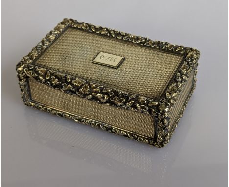 A Victorian silver gilt table oblong snuff box with applied carved border, engine turned all around with initialled cartouche