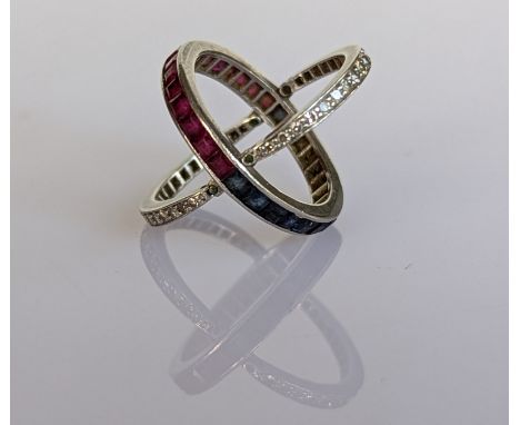 A sapphire, ruby and diamond hinged eternity or 'Day and Night' ring on a channel-set, white metal setting, unmarked but test