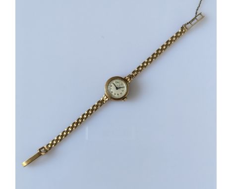 A mid-century ladies dress watch by Record with a pierced gold strap and gold case, hallmarked 9ct, 14g and a crucifix pendan