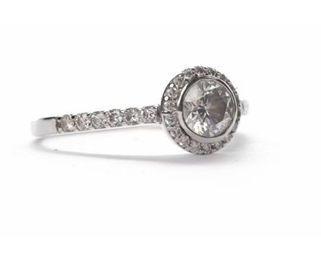 DIAMOND SOLITAIRE RINGthe round brilliant cut diamond of approximately 0.60 carats surrounded by further smaller round diamon