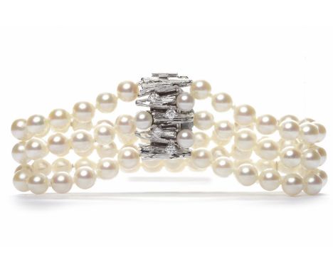 THREE STRANDED PEARL BRACELETformed by spherical white pearls 6.3mm diameter, with a pearl and diamond set clasp, the clasp m