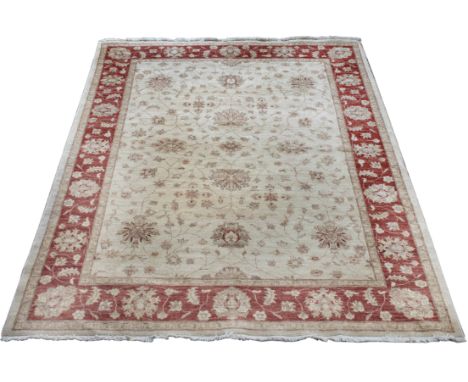 A ZIEGLER PASTEL GROUND SMALL CARPET decorated with a simple scrolling foliate motif within a mid red border, 265cm x 190cm