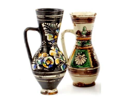 A GROUP OF THREE ANTIQUE TURKISH TIN GLAZED AND ENAMEL DECORATED TERRACOTTA JUGS of baluster form with flaring rims and shape