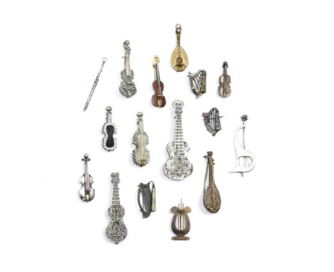 FOUR CONTINENTAL WHITE METAL FILIGREE BROOCHES in the form of musical instruments, two guitars, a lute and a violin together 