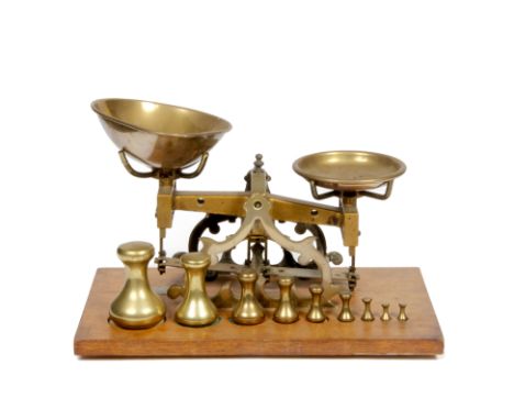 A SET OF BRASS FRAMED SCALES on a mahogany veneered plinth base, the stand stamped 'C Stevens, London England', complete with