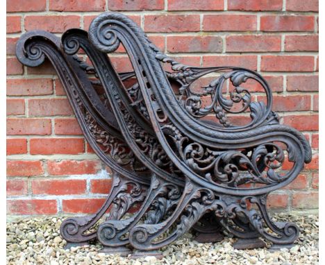 A VICTORIAN CAST IRON BENCH FRAME of scrolling form decorated with acanthus leaves with two ends and a central section, each 