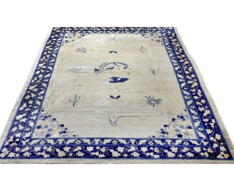 AN ANTIQUE CHINESE BLUE AND PALE CAMEL GROUND CARPET, the central panel with a simple design of foliate sprigs and butterfly 