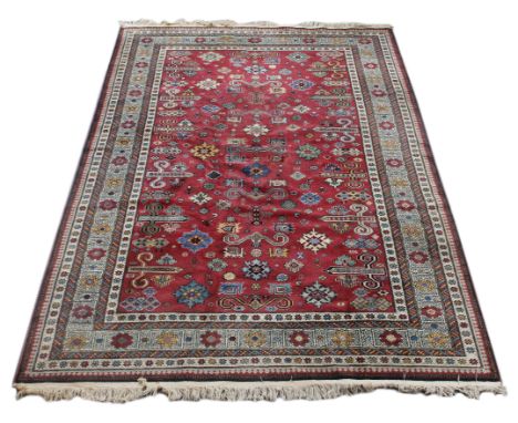 A MIDDLE EASTERN KAZAK AUBERGINE GROUND SMALL CARPET with a multiple banded border and all over stylised motifs, 201cm x 317c