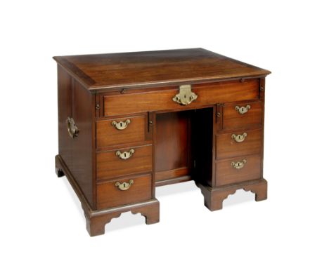 A GEORGE III MAHOGANY PARTNERS DESK, having a slide and an arrangement of seven drawers around a recessed cupboard to one sid