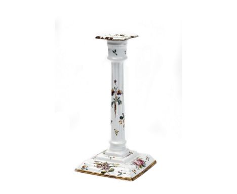 A GEORGE III BATTERSEA ENAMEL CANDLESTICK of white ground decorated with floral sprays with square drip pan, fluted column st