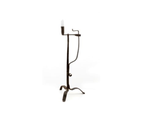 AN ANTIQUE WROUGHT IRON RUSH LIGHT HOLDER with sprung stay together with a candle socket on a square section stem and tripod 