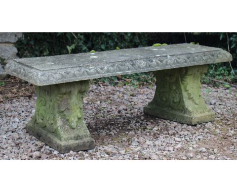 AN OLD RECONSTITUTED STONE RECTANGULAR TOPPED GARDEN BENCH with scroll and acanthus leaf decorated supports to either end 123