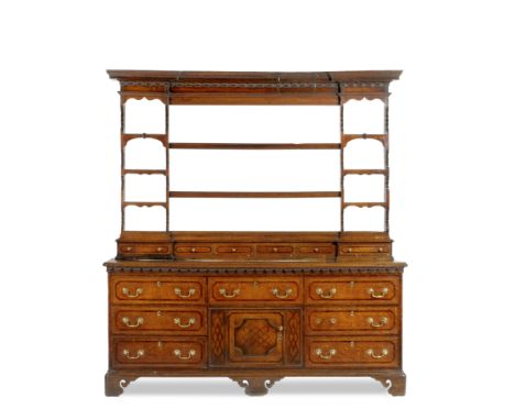 A GEORGE III NORTH COUNTRY OAK DRESSER the inverse breakfront plate rack surmounted by a cornice with shaped dogtooth decorat