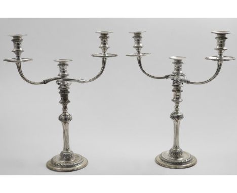 A PAIR OF ELIZABETH II CAST THREE-LIGHT CANDELABRA  on round bases with "well" centres, fluted and shouldered columns with an