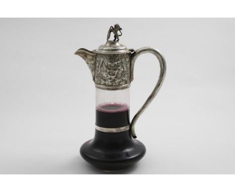 A VICTORIAN MOUNTED CLEAR GLASS CLARET JUG with a bulbous lower body &amp; star-cut base, the mount chased with masks, vines 
