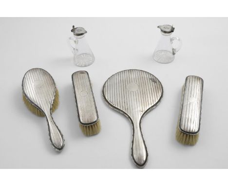 TWO GEORGE V MOUNTED GLASS WHISKY TOTS OR CHOTA PEGS with star-cut bases, the covers engraved with the Order of the Garter, b