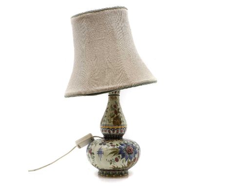 A Delft pottery lamp late 18th century, decorated with polychrome flowers, painted marks 'Gouda Holland', with a shade, 33cm 
