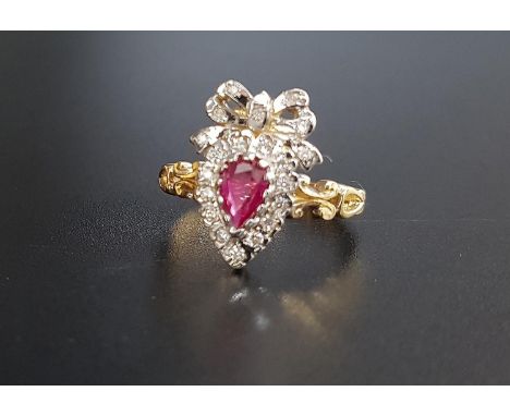 UNUSUAL RUBY AND DIAMOND CLUSTER RINGthe pear cut ruby in diamond surround and surmounted by a diamond set bow, on eighteen c