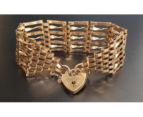 NINE CARAT GOLD SEVEN BAR GATE BRACELETwith decorative twisted links, with nine carat gold heart padlock clasp a safety chain
