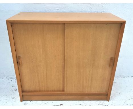 LIGHT MAHOGANY BOOKCASEthe rectangular top above a pair of sliding doors with an adjustable shelf, standing on a plinth base,