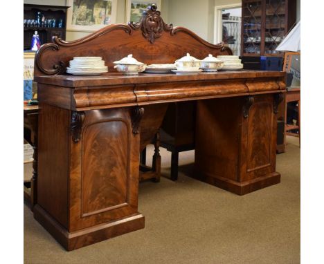 Victorian mahogany twin pedestal sideboard having a foliate scroll carved back, the rectangular top over shaped frieze drawer