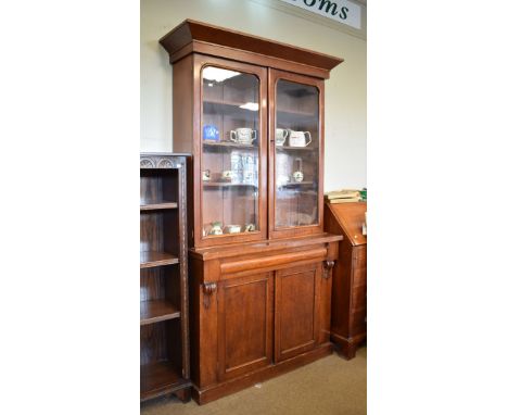 Victorian mahogany bookcase on cabinet, the upper stage having a pair of glazed doors enclosing three adjustable shelves, the