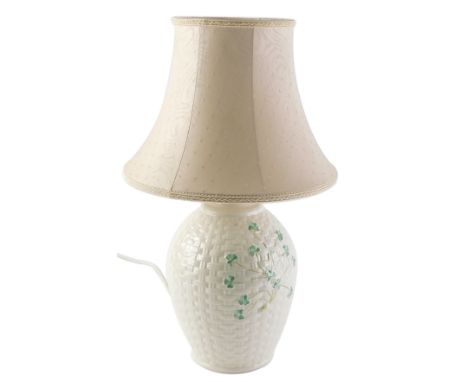 A Belleek porcelain lamp base, with stylised basket work decoration embellished with shamrocks, and a shade, the base 32cm hi