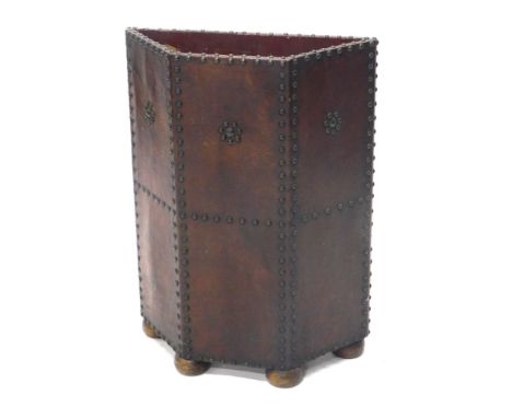 A 20thC leather and studwork stick stand, raised on four ball feet, 68cm high, 50cm wide.