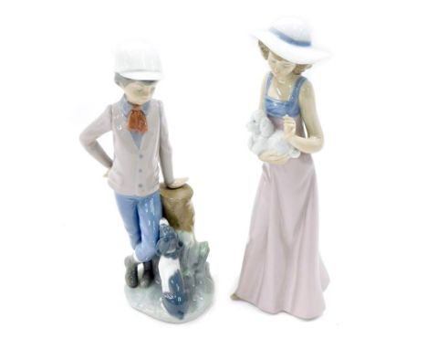 Two Nao porcelain figures, modelled as lady holding dog, and young boy leaning against tree stump beside dog.