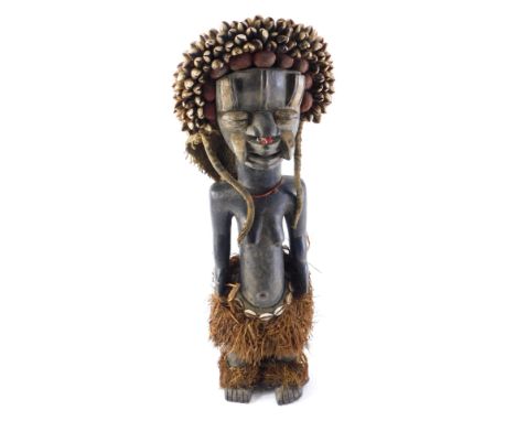 A Dan Guere figure with cowrie shells, Cote D'Ivoire, approximately 60-80 years old, 58cm high.