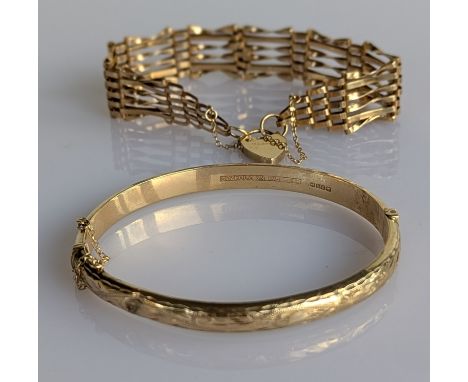 A yellow gold hinged bangle with etched decoration, 60mm, and a gate-link yellow gold bracelet with heart locket, 16 cm, both