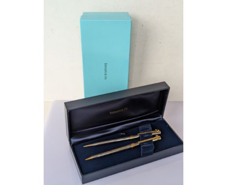 A Tiffany & Co. silver and gold tone ballpoint pen and pencil with T-clips, both signed Tiffany & Co. USA, one inscribed STUD
