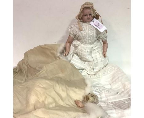 A 19th century wax shoulder head doll, with fixed blue glass eyes, cloth body and partial wax legs (one foot missing, damage 