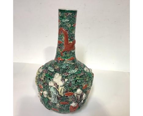 A Chinese porcelain reticulated vase, 19th century, of bottle form, decorated in relief with figures and clouds, a dragon enc