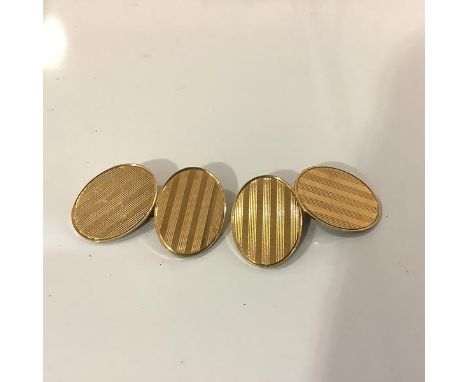 A pair of 18ct gold chainlink cufflinks, each of twin oval plaques with engine-turned decoration, stamped "18ct". Plaques 17m