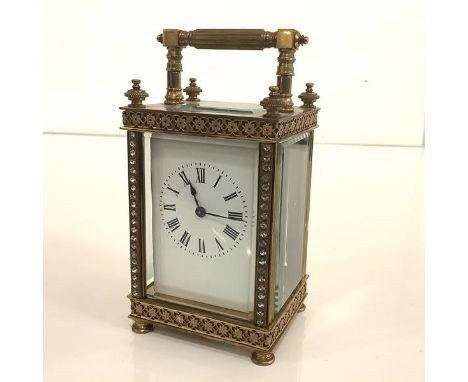 A late 19th century brass carriage clock, of characteristic form, the white enamel dial with Roman numerals within a case cas