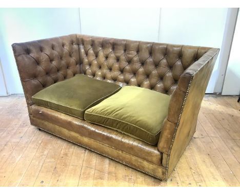 A buttoned leather Knole-style sofa, with loose fabric seat cushions, the frame with close nail edge, raised on castors. 86cm