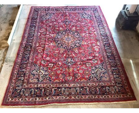 A Meshad carpet, North-West Persian, the central indigo-framed medallion within a red field, all-over decorated with conjoine