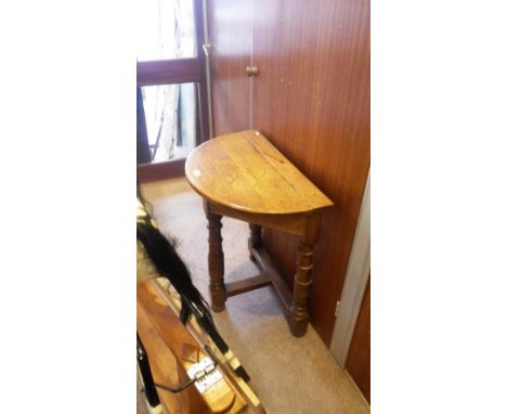 A reproduction oak console table of triangular form with lift open demi-lune top 27" wide