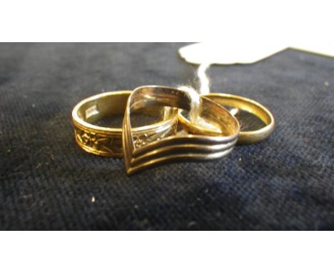 A 22ct yellow gold wedding band with engraved flower and dart decoration, another similar and a 9ct gold 'Wishbone' ring